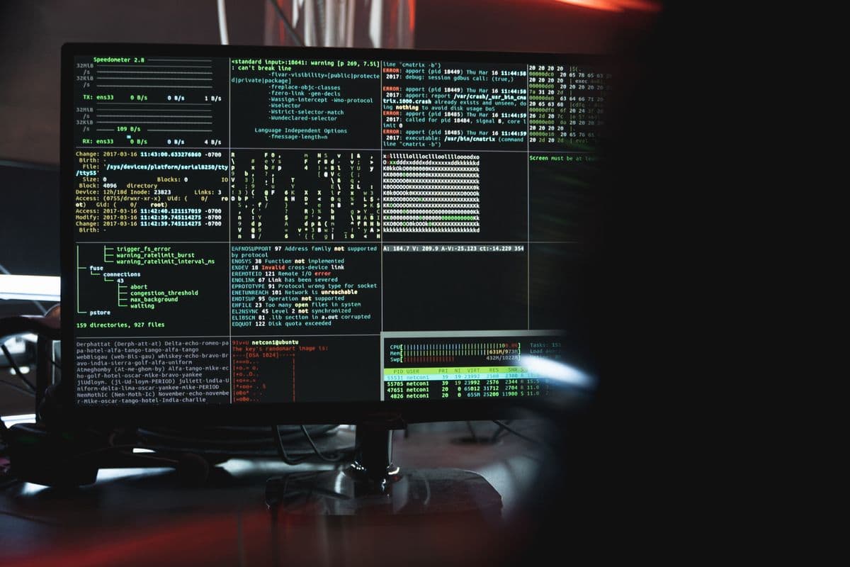 A computer monitor filled with green terminal output in a dark room