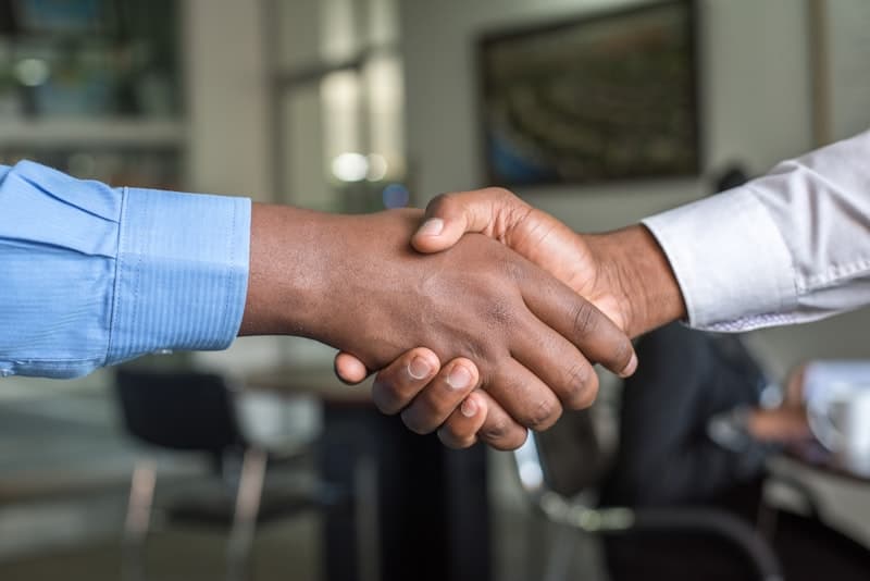 Two people shaking hands in a professional office setting