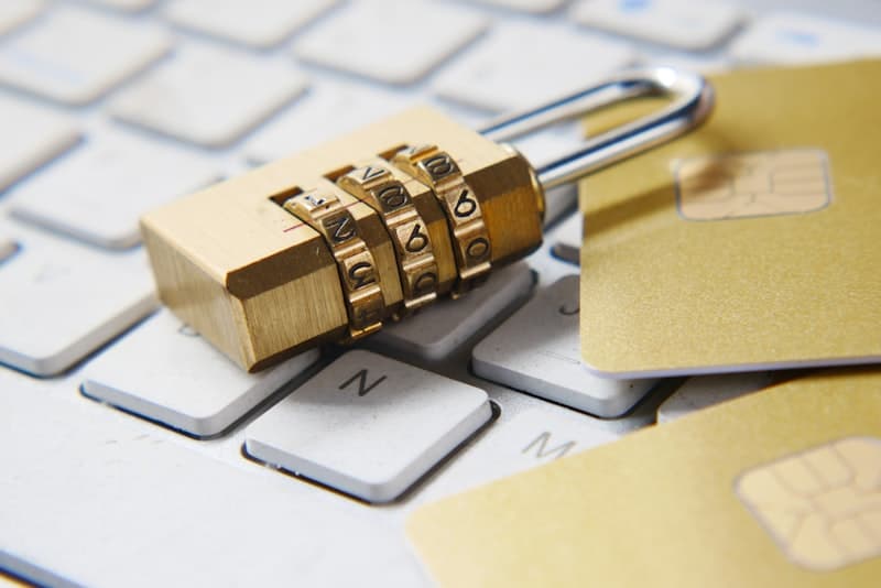 Combination padlock on a keyboard next to credit cards representing digital security